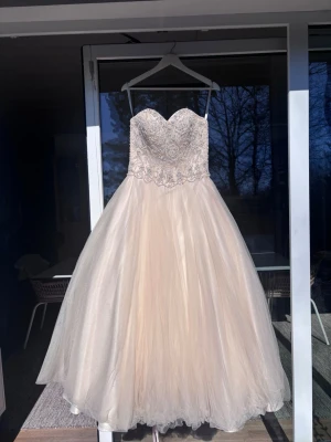 Champagnefärgad bal-klänning med spets - Nu säljer jag min balklänning från 9:ans bal! Inköpt för två år sedan och har hållit fast i den  för nostalgiska anledningar. Men nu är det dags för den att gå vidare till nån annan som kommer ta hand om den. Den är i färgen champagne och är i storlek 34, men eftersom den har en korsett rygg så är storleken anpassningsbar! Kemtvättad efter senaste användningen. OM NI HAR MÖJLIGHET ATT HÄMTA I STOCKHOLM ÄR DET BÄST! 