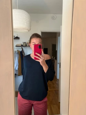 Mörkblå topp - Säljer en mårkblå off shoulder topp med lös passform och medellånga ärmar. Toppen har en bred urringning som kan bäras på flera olika sätt. Materialet är mjukt och stretchigt. Nyskick.
