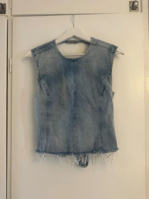 Jeanstopp med knyt i ryggen - Snygg jeanstopp i blå denim med helt öppen rygg.  knyt i ryggen. Använd ett fåtal gånger