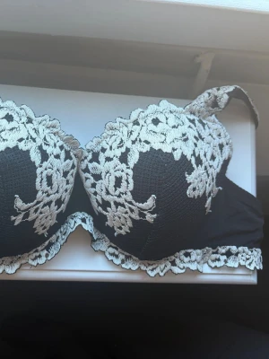 Svart bh med vit spetsbrodyr - Jag säljer min bh från Intimissimi i storlek 75B. Jag säljer den eftersom den är ganska stor på mig. Den är i perfekt skick, jag köpte den nyligen. Jag har tagit bort etiketten eftersom den skavde ganska mycket. Jag har använt den tre gånger, priset kan diskutera!