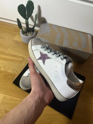 Golden Goose tjej  - Golden Goose sneakers – stl 39  Säljer ett par Golden Goose i mycket fint skick. Endast använda vid något enstaka tillfälle, så de är i princip som nya.  Skorna tillhör min tjej som köpte dem via Vinted med verifiering, men storleken passade tyvärr inte – därför säljs de vidare.  Storlek: 39 Skick: Nästan nyskick Nypris: (7000) Pris: (2899kr) Hör av dig vid frågor eller om du vill ha fler bilder, Kan även diskutera priset vid snabb affär:) 