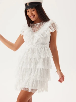 Vit spetsklänning/studentklänning med volanger - Superfin vit kortklänning med flera lager volanger och spetsdetaljer. Klänningen har en v-ringad spetsfront, korta ärmar och transparenta partier upptill. Pärlor i bak. Passar mig som har S/M. Fler bilder kan fås. Perfekt för student! 