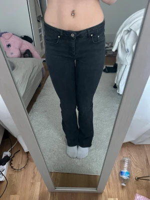 Svarta bootcut jeans med stretch - Säljer ett par svarta bootcut jeans med klassisk femficksdesign och normal midja. Jeansen har en snygg, smal passform upptill och lätt utsvängda ben. Materialet är stretchigt för extra komfort. Perfekta till sneakers eller boots.
