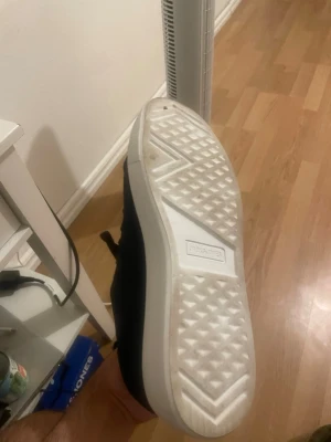Svarta sneakers med vit sula - Stilrena mörk blå sneakers med tjock vit sula och klassisk låg profil. Ovandelen är i mockaliknande material och skorna har svarta skosnören. Passar perfekt till streetwear och casual outfits.