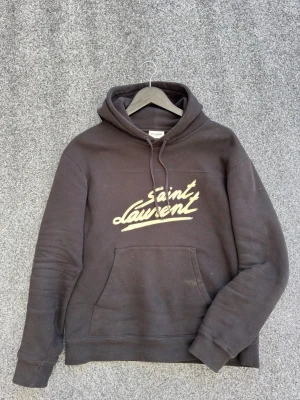 Saint laurent hoodie - FETASTE HOODIEN PÅ MARKNADEN!! Säljer denna sjukt feta och extremt eftertraktade saint laurent 50s hoodie. Garanterad äkthet. Size S men passar även xs. Skick 8/10 2 slitningar finns ( se bilder) hör av dig vid frågor eller funderingar 💯
