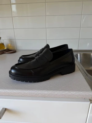 Loafers från Pier One - Stilrena svarta loafers från Pier One i blankt läder med klassisk pennyloafers-design. Skorna är använda MAX 5 gånger. Superfint skick