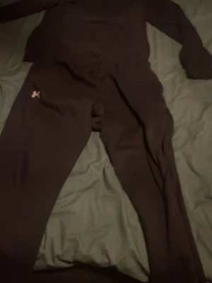 Svart  Under Armour - Säljer ett svart  sett Armour med matchande hoodie och byxor. Setet har diskret logga på både tröja och byxa, mjukt material och klassisk passform. Perfekt för gymmet eller chill hemma.
