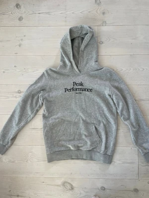 Grå hoodie från Peak Performance (barn) - Snygg grå hoodie från Peak Performance i storlek 160. Använd fåtal gånger och är o mycket bra skick 