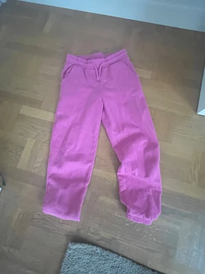 Rosa mjukisbyxor från Eternity - Säljer ett par rosa mjukisbyxor från Eternity med resår i midjan och dragsko. Byxorna har fickor på sidorna och resår vid bensluten. Perfekta för en chill dag hemma eller när du vill vara bekväm. Materialet är mjukt och skönt.💕🌺😻