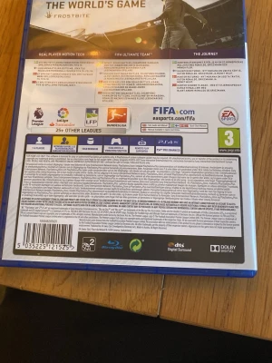 FIFA 18 till PS4 - FIFA 18 till PlayStation 4 med blå plastfodral. Omslaget har en fotbollsspelare i vit tröja och spelet har PEGI 3-märkning. Perfekt för dig som gillar fotbollsspel och vill spela med lag från La Liga, Bundesliga och fler ligor.