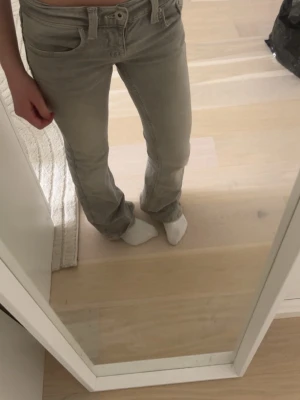 Grå lowrise bootcut jeans - Snygga grå jeans med bootcut-modell. Klassisk femficksdesign och diskreta sömmar.