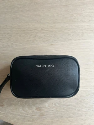 Svart necessär från Valentino - Svart necessär från Valentino. Sparsamt använd, liten repa på kanten av under sidan (skickar vid intresse). 