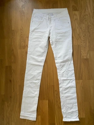 Vita skinny jeans med låg  midja - Superfina och fräscha vita jeans från Gina Tricot i modellen Alisson. De har låg midja (low waist) och en jätteskön stretch som gör att de sitter väldigt bekvämt!  Perfekta sommarjeans till både vardag och fest. Jeansen är i mycket fint skick, hela och fläckfria.  Material: * 96% Bomull * 4% Spandex (ger härlig stretch!)  Mått tagna platt: * Midjemått: ca 35 cm (totalt ca 70 cm runt om) * Innerbenslängd: ca 83 cm * Midjehöjd: Låg midja (grenhöjd ca 19 cm) Storlek: W27 (motsvarar Small / 36) 