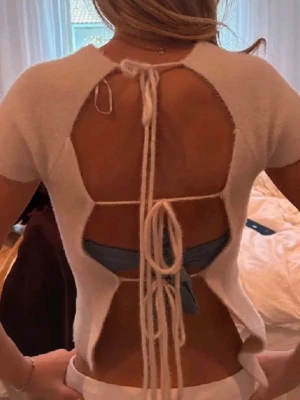 Topp T-shirt  med öppen rygg och snörning zara - Trendig topp i mjukt material med korta ärmar och öppen rygg. Snygga snörningsdetaljer längs ryggen som ger en unik look. Aldrig använd! Inga defekter 