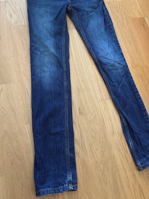 Mörkblå levis jeans - Säljer ett par mörkblå jeans med rak passform och klassisk femficksdesign. Jeansen har subtila slitningar och kontrastsömmar. Perfekta till en avslappnad stil och tillverkade i mjukt denimtyg. Barn storlek btw