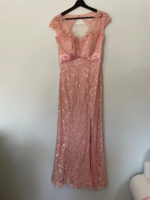 Rosa festklänning  - Använd en gång.  inga fläckar, finns lite normalt slitage. Längd: ca 143 cm Byst : ca 44,5 cm Midjan: ca 38 cm