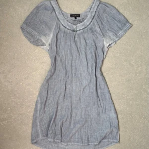 Ljusblå blus - Vintage gråblå lång blus / kort klänning från Alice Bizous i ett tunt, luftigt tyg. Blusen har korta ärmar, rundad halsringning med dekorativ kant och två små knappar framtill. Lite nopprig, se sista bild!❤️