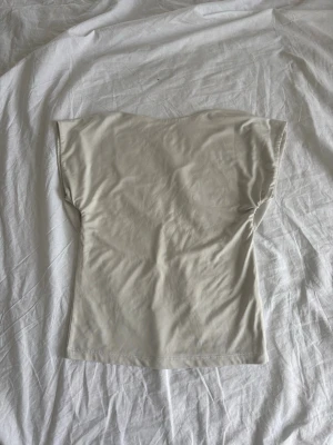 Beige kortärmad topp i mjukt tyg - En stilren beige topp med korta ärmar och rund halsringning. Tillverkad i ett mjukt och stretchigt material som sitter bekvämt mot kroppen. Perfekt att matcha med jeans eller kjol för en enkel och clean look. Toppen har en öppen rygg !💓 Packas och postas säkert!
