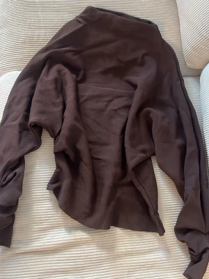 Brun oversized  tröja - Brun tröja med lite tajtare dra vid midjan och detaljer vid ärmarna .