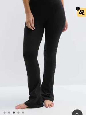 Svarta utsvängda leggings från ginatricot  - Snygga svarta leggings med utsvängda ben och hög midja. Stretchigt material som sitter bekvämt och följer kroppen. Perfekta för en trendig och avslappnad stil.