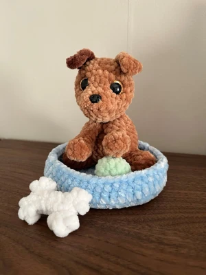Virkad hund - Virkad hund med en säng, en boll och ett tuggben☺️ Hunden är cirka 12cm hög och allt är virkat i mjukt garn💗