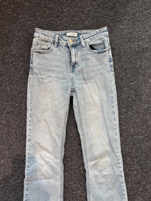 Ljusblå utsvängda jeans - Snygga ljusblå jeans med utsvängd passform och klassisk femficksdesign. Jeansen har normal midja och stängs med knapp och dragkedja. Tillverkade i denim med en tvättad look. 