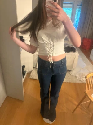 Vit croppad topp med snörning - Trendig vit croppad topp med snörning framtill och korta ärmar. Pris kan diskuteras ❣️.