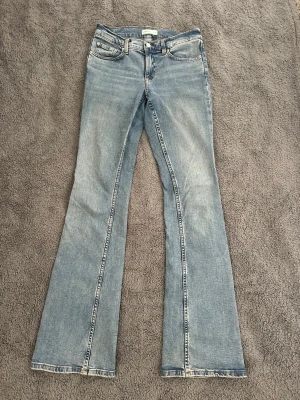 Ljusblå bootcut jeans med utsvängda ben - Säljer ett par ljusblå bootcut jeans med  utsvängda ben. Jeansen är köpta på Gina Tricot för drygt ett år sedan, men är endast använda ett fåtal gånger. Modellen är tall och passar mig som är 176 cm lång. Jeansen är köpta för 500kr. 