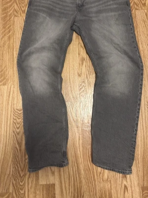 Helt Nya Gråa regular fit jeans från H&M - Snygga gråa jeans från H&M i regular fit-modell. Jeansen har klassisk femficksdesign, raka ben och en lätt tvättad look för en avslappnad stil. Perfekta till vardags och passar till det mesta i garderoben.