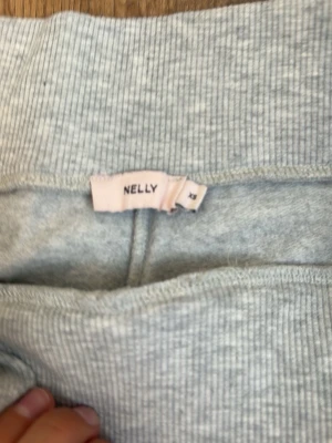 Ljusgrå mjukisbyxor från Nelly - Superbekväma ljusgrå mjukisbyxor från Nelly med dragsko i midjan och raka ben. Perfekta för chill dagar hemma eller när du vill ha en avslappnad stil. Mjukt material som känns skönt mot huden. Vädligt bra på hösten då dem är svalkande men ändå håller värmen andvänd några gånger och i bra kvalité om de behövs flera bilder kp orginall priset är 299kr