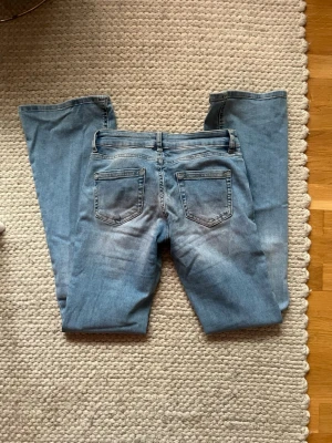 Ljusblå bootcut jeans från ONLY - Säljer ett par ljusblå bootcut lowwaist jeans från ONLY storlek 32 men passar 32-34