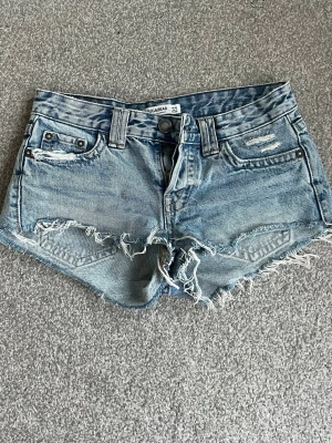 Blå jeansshorts med fransig kant - Snygga blå jeansshorts med fransig och rå kant nertill. 