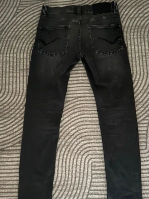 Svarta grisch washed slim fit  Only & Sons jeans - Säljer ett par svarta slim fit  jeans med tvättade detaljer på låren. Jeansen har klassisk femficksmodell och smal passform hela vägen ner. Materialet är stretchigt för extra komfort.