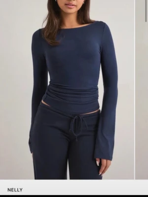 Mörkblå långärmad topp från Nelly - Snygg mörkblå långärmad topp från Nelly med tight passform med boat neck. Aldrig andvänd med prislapp kvar. pris går att diskuteras. Storlek S