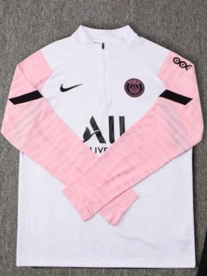 PSG träningströja vit/rosa Nike för mer bilder kom till DM - Säljer en snygg PSG träningströja från Nike i vitt med ljusrosa ärmar och svarta detaljer. Tröjan har halv dragkedja, lång ärm och klubbmärke på bröstet. Perfekt för fotbollsträning eller chill. Materialet är troligtvis polyester.