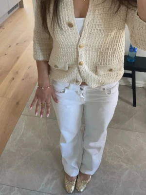 Krämvit kofta från Zara med guldknappar - Snygg krämvit kofta från Zara med strukturerad stickning och guldknappar framtill. Från Zara i fint skick 