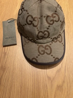 Beige Gucci keps - Säljer en beige Gucci keps  Väldigt snygg och lyxig. Perfekt för dig som gillar exklusiva accessoarer.