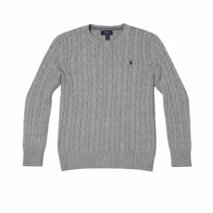 Grå kabelstickad tröja Polo Ralph Lauren - Kabelstickad tröja i ljusgrått från Polo Ralph Lauren med rund halsringning och diskret broderad logga på bröstet. Tröjan har långa ärmar och ribbade muddar vid ärmslut och nederkant. Tillverkad i mjukt material för en klassisk look. Tröjan är i perfekt skicka endast använd tre gånger. Nytt pris 2099kr. Priset är ej hugget i sten kan sänka vid snabb affär