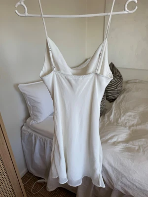 Vit klänning storlek M - Säljer en vit kort klänning med justerbara axelband från Bershka. 