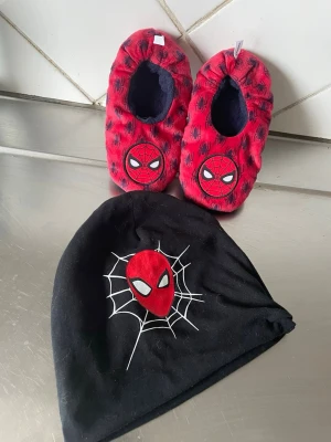 Svart Spiderman mössa passar 4-7 åringar  - Cool svart mössa med Spiderman-motiv och vit spindelnätsdetalj framtill. Perfekt för dig som gillar superhjältar och vill ha en snygg accessoar till hösten eller vintern. Tillverkad i mjukt och stretchigt material för skön passform.    Endast provade då de var för smått 