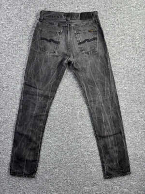Nudie Jeans Steady Eddie Dry Black 30/34 – Sjuka Fades - Säljer ett par Nudie Jeans Steady Eddie Dry Black i storlek 30/34.  Riktigt snyggt inslitna med kraftiga, naturliga fades och tydlig karaktär. Dry denim som brutits in perfekt – går inte att köpa såhär i butik 🔥 📌 Modell: Steady Eddie 📌 Storlek: 30/34 📌 Dry Black denim 📌 Fantastiska fades 📌 Klassisk straight fit Perfekta för dig som gillar raw denim, vintage vibes eller unik denim med personlighet. 📏 Mått finns i bilderna 🔎 Skick syns tydligt på bilderna 💸 Följ mig och få 10% rabatt!