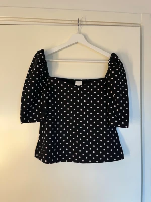 Svart prickig topp med puffärm - Säljer en superfin svart topp med vita prickar och puffiga korta ärmar. 