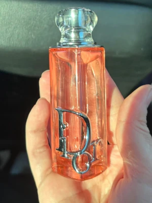 Dior Addict Peachy Glow EdP 30ml - Dior Addict Peachy Glow Eau de Parfum i en elegant, persikofärgad glasflaska med silverdetaljer och tydlig Dior-logga. Flaskan har en lyxig, genomskinlig kork och rymmer 30 ml. Kommer i en snygg metallicförpackning med rosa detaljer.