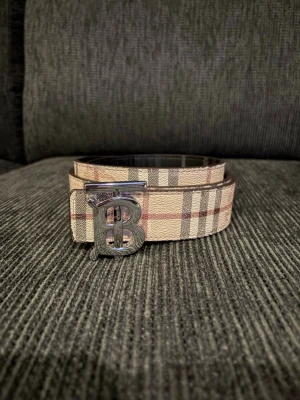 Bberry bälte - Begagnat bälte, har några extra hål. Går att vända bältet åt andra hållet då blir bältet svart. 115 cm långt 