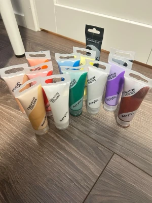 Set med akrylfärger  - Säljer ett set med 13 tuber akrylfärg i olika nyanser som röd, blå, grön, gul, lila, svart, vit, guld, silver och fler. Perfekt för dig som gillar att måla och skapa konst. Tubformat gör dem enkla att använda och förvara.