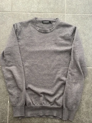 Grå stickad tröja från J.Lindeberg - Mjuk och stilren grå stickad tröja från J.Lindeberg. 