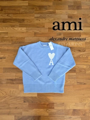 Ami Paris Sweatshirt - 💙 AMI Paris Tröja – Ljusblå, Nyskick 💙 Elegant ljusblå tröja från AMI Paris i storlek M. Rund hals med ribbad kant, ribbade ärmslut och nederkant för perfekt passform. Fram på bröstet syns det ikoniska AMI-hjärta med A i vitt. Tillverkad i mjukt, högkvalitativt material som känns skönt mot huden. Nyskick med tagg kvar – perfekt för vardag eller stilfullt casual. 📦 Snabb leverans – kontakta vid frågor! plagg.