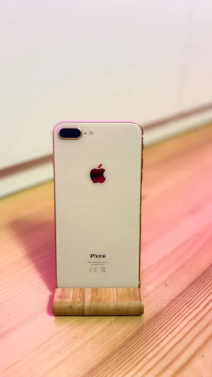 iPhone 8 Plus vit med Touch ID - Snygg iPhone 8 Plus i vit färg med glasbaksida och rundade kanter. Telefonen har dubbla kameror på baksidan, Touch ID, kommer med 2 skal och ett fodral. Spricka längst ner till vänster (se bild). Baksidan och kanterna är annars helt stilrena. Lite färg på de ena gröna skalet. 