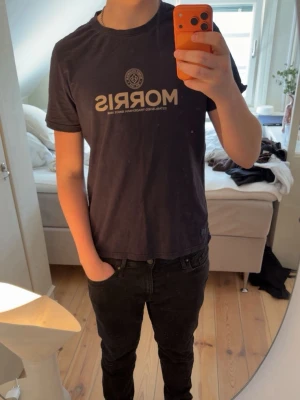 Morris t-shirt  - Snygg mörkblå t-shirt från Morris med beige tryck på bröstet och rund hals. Jag är 1,85 och den sitter bra men nästintill för kort