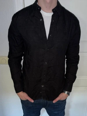 Svart linneskjorta från Morris - Svart linneskjorta från Morris i storlek S.  Fint skick till ett bra pris. Nypris: 1995kr. Mitt pris: 299kr. Vid frågor eller funderingar, tveka inte att höra av dig.